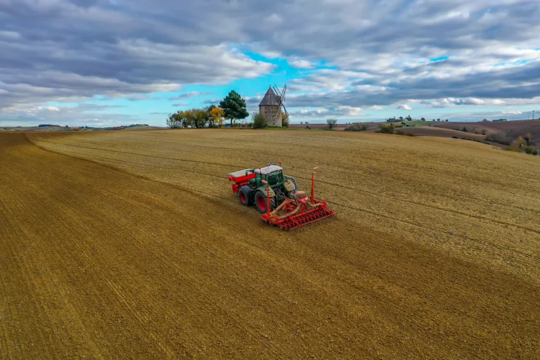Photo aérienne par drone d'un tracteur dans un champ près d'un moulin